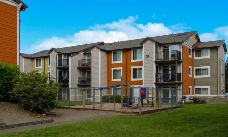 A playground between two multicolor apartment buildings.